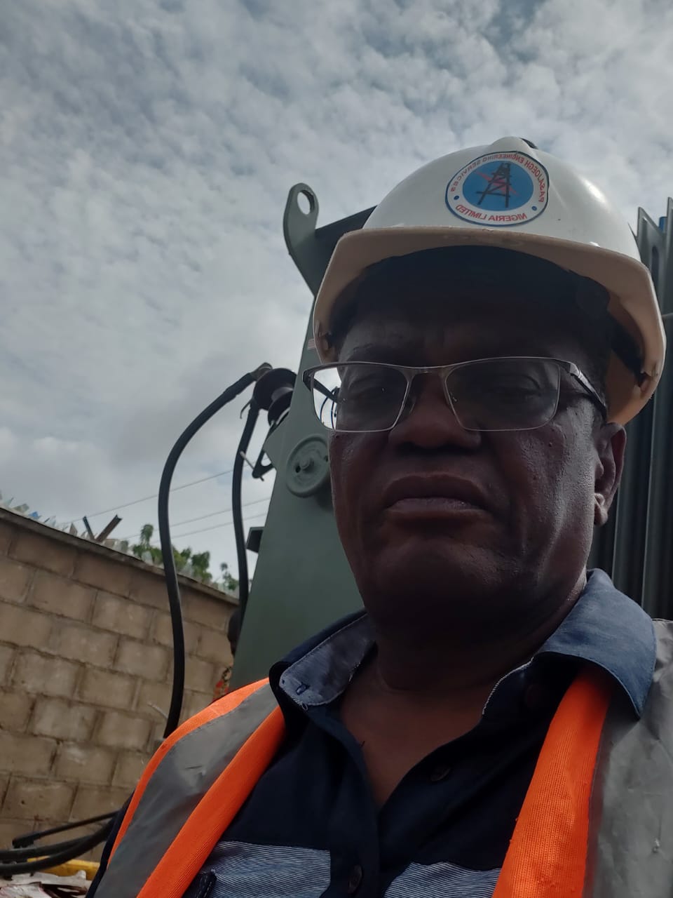 Engr. Francis Okosobo-Ibe in a Pasajoegh-branded safety helmet and high-visibility vest on an electrical project site