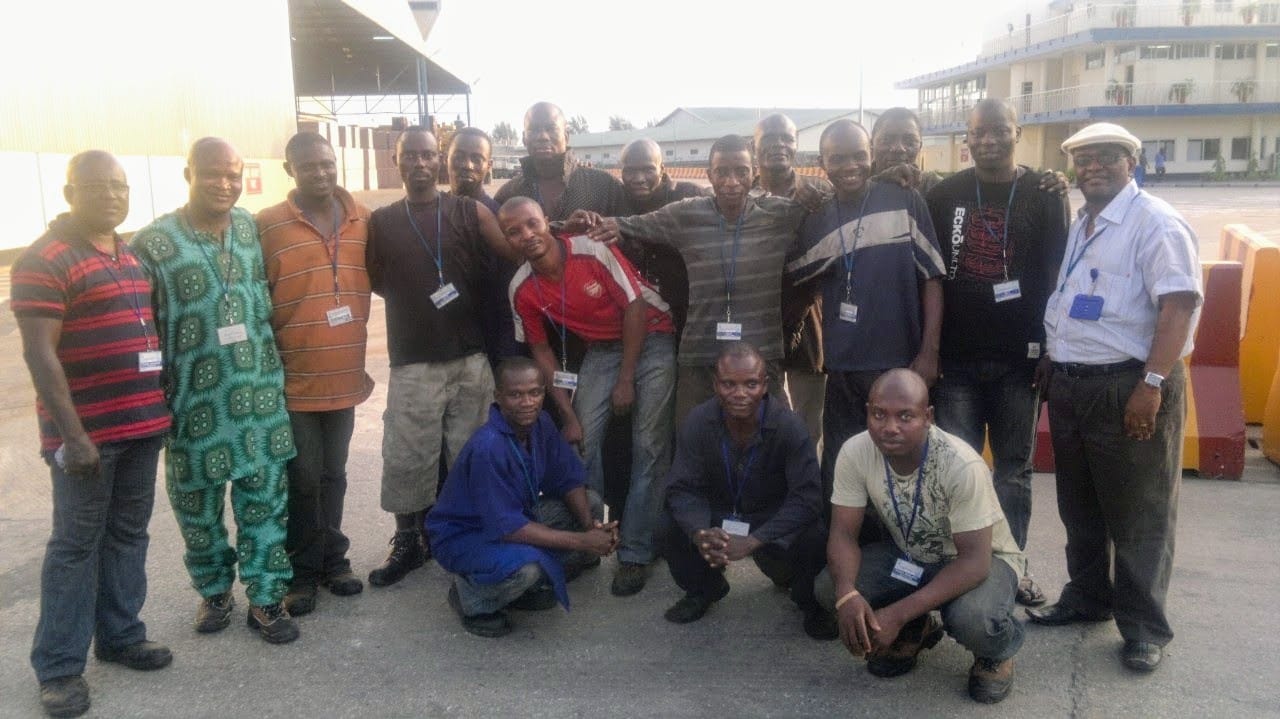 Large project team wearing site identification passes photographed together at an industrial facility